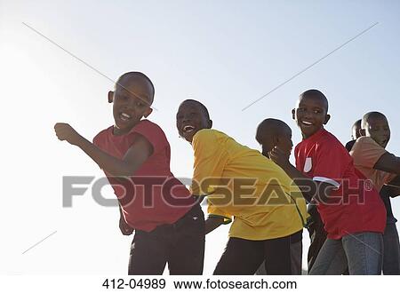 Boys playing together in dirt field View Large Photo Image Stock Photo - Boys playing together in dirt field. Fotosearch