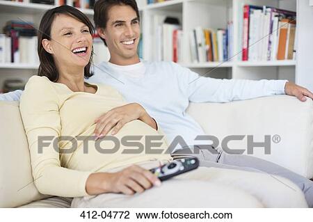 Couple watching television on sofa View Large Photo Image Stock Image - Couple watching television on sofa. Fotosearch