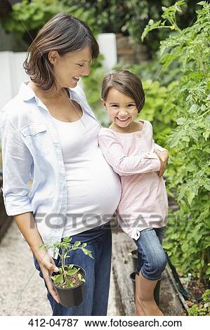 Girl and pregnant mother gardening together View Large Photo Image Stock Photo - Girl and pregnant mother gardening together. Fotosearch