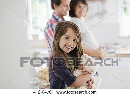 Girl holding teddy bear in kitchen View Large Photo Image Stock Image - Girl holding teddy bear in kitchen. Fotosearch