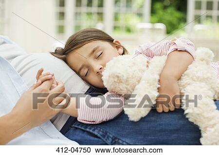 Stock Image - Girl napping on pregnant mother's la. Fotosearch