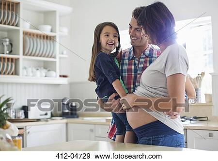 Stock Photo - Girl touching pregnant mother's bell. Fotosearch