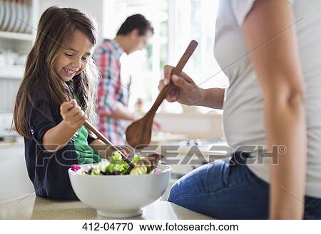 Mother and daughter tossing salad together View Large Photo Image Stock Image - Mother and daughter tossing salad together. Fotosearch