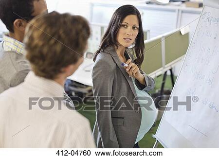 Stock Image - Pregnant businesswoman talking in meeting. Fotosearch
