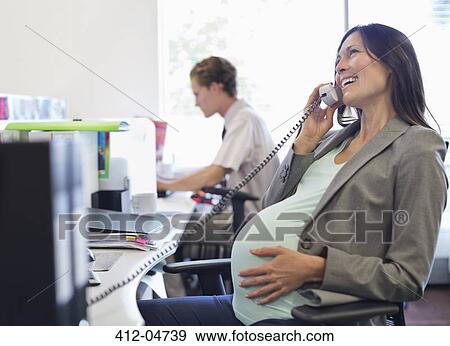 Stock Photo - Pregnant businesswoman talking on telephone. Fotosearch