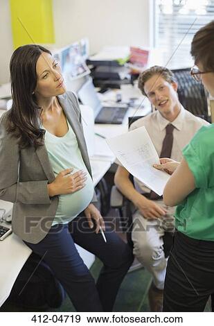 Stock Photo - Pregnant businesswoman talking to colleagues. Fotosearch