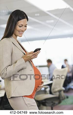 Pregnant businesswoman using cell phone View Large Photo Image Stock Photo - Pregnant businesswoman using cell phone. Fotosearch