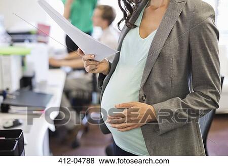 Pregnant businesswoman working in office View Large Photo Image Stock Photo - Pregnant businesswoman working in office. Fotosearch