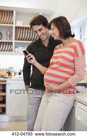 Pregnant woman and boyfriend using cell phone View Large Photo Image Stock Image - Pregnant woman and boyfriend using cell phone. Fotosearch