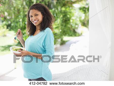 Stock Image - Pregnant woman eating salad. Fotosearch