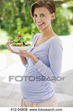 Pregnant woman eating salad View Large Photo Image Stock Photo - Pregnant woman eating salad. Fotosearch