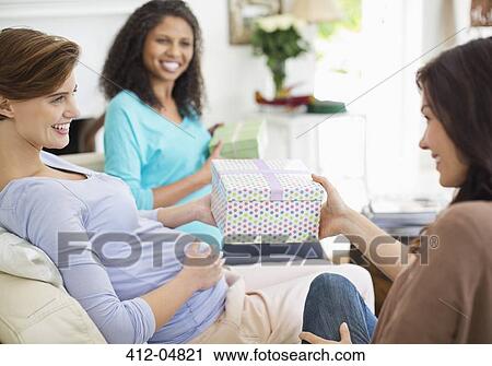Stock Image - Pregnant woman having baby shower. Fotosearch