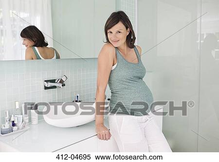 Pregnant woman leaning on bathroom sink View Large Photo Image Stock Photography - Pregnant woman leaning on bathroom sink. Fotosearch