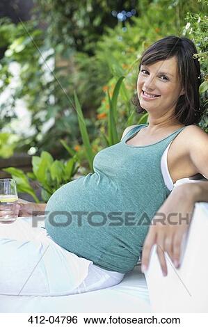 Pregnant woman relaxing outdoors View Large Photo Image Stock Photograph - Pregnant woman relaxing outdoors. Fotosearch
