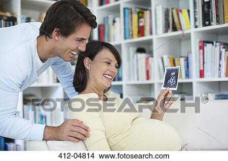 Pregnant woman showing boyfriend sonogram View Large Photo Image Picture - Pregnant woman showing boyfriend sonogram. Fotosearch