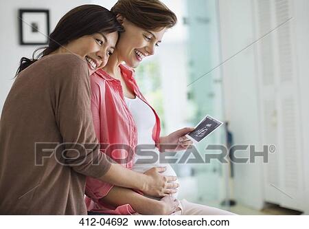 Pregnant woman showing friend sonogram View Large Photo Image Stock Image - Pregnant woman showing friend sonogram. Fotosearch