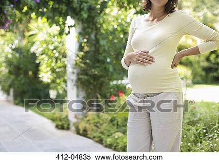 Stock Photography - Pregnant woman standing outdoors. Fotosearch