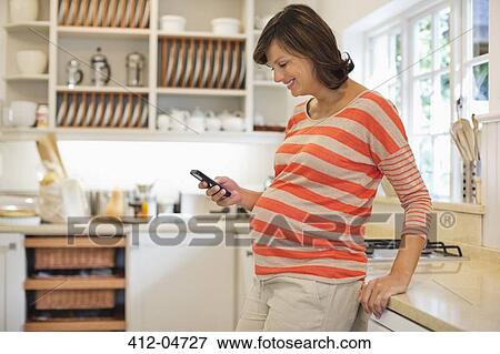 Pregnant woman using cell phone View Large Photo Image Stock Photo - Pregnant woman using cell phone. Fotosearch