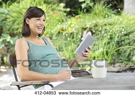 Pregnant woman using tablet computer View Large Photo Image Stock Image - Pregnant woman using tablet computer. Fotosearch