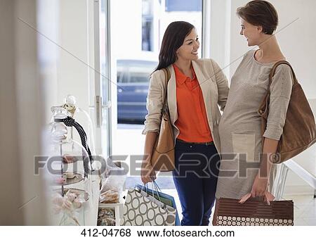 Stock Photo - Smiling women shopping together. Fotosearch