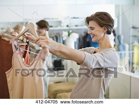 Woman shopping for clothes in store View Large Photo Image Stock Photography - Woman shopping for clothes in store. Fotosearch