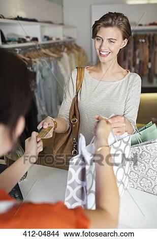 Woman shopping in clothes store View Large Photo Image Picture - Woman shopping in clothes store. Fotosearch
