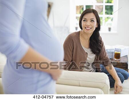 Woman smiling at pregnant friend View Large Photo Image Stock Photo - Woman smiling at pregnant friend. Fotosearch
