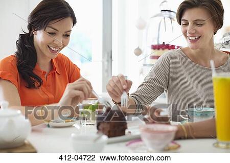 Stock Image - Women eating cake together. Fotosearch