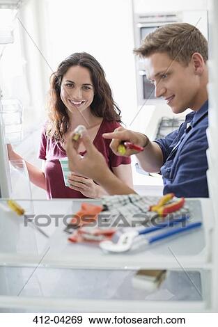Electrician talking to client in kitchen View Large Photo Image Stock Photo - Electrician talking to client in kitchen. Fotosearch