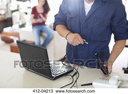 Electrician using laptop in home View Large Photo Image Stock Image - Electrician using laptop in home. Fotosearch
