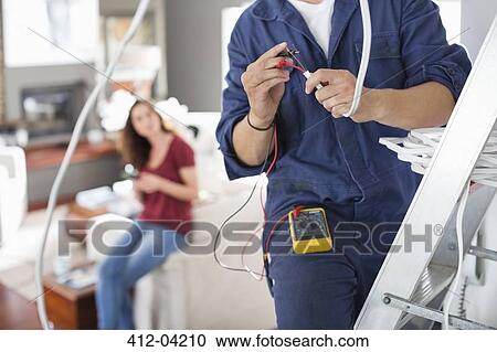 Electrician working in living room View Large Photo Image Stock Image - Electrician working in living room. Fotosearch