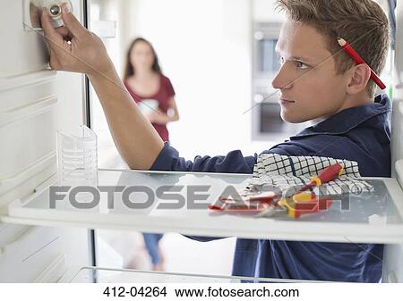Electrician working on fridge in home View Large Photo Image Picture - Electrician working on fridge in home. Fotosearch