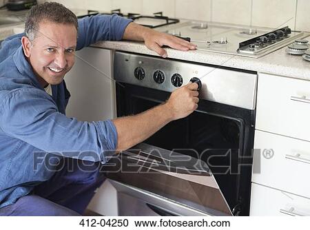 Electrician working on oven in kitchen View Large Photo Image Stock Image - Electrician working on oven in kitchen. Fotosearch