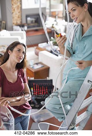 Female electrician talking to client in home View Large Photo Image Stock Photograph - Female electrician talking to client in home. Fotosearch