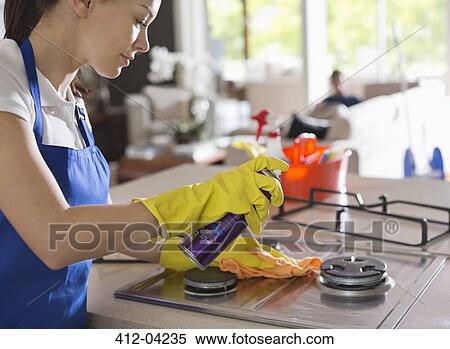 Maid cleaning stove top View Large Photo Image Stock Photography - Maid cleaning stove top. Fotosearch