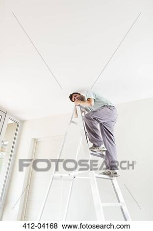 Man climbing ladder indoors View Large Photo Image Stock Photo - Man climbing ladder indoors. Fotosearch