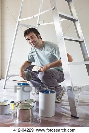 Man examining paint cans in room View Large Photo Image Stock Photo - Man examining paint cans in room. Fotosearch