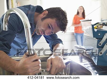 Plumber working on kitchen sink View Large Photo Image Stock Image - Plumber working on kitchen sink. Fotosearch