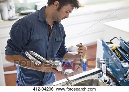 Plumber working on kitchen sink View Large Photo Image Stock Photograph - Plumber working on kitchen sink. Fotosearch