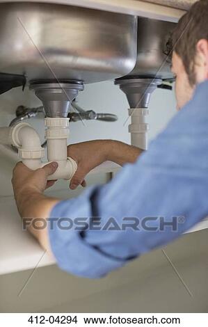 Plumber working on pipes under sink View Large Photo Image Picture - Plumber working on pipes under sink. Fotosearch
