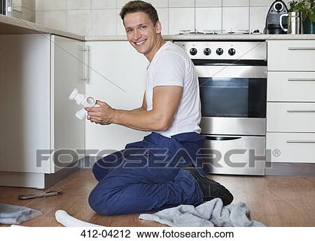 Plumber working on pipes under sink View Large Photo Image Stock Image - Plumber working on pipes under sink. Fotosearch