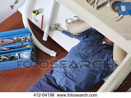 Plumber working on pipes under sink View Large Photo Image Stock Photo - Plumber working on pipes under sink. Fotosearch