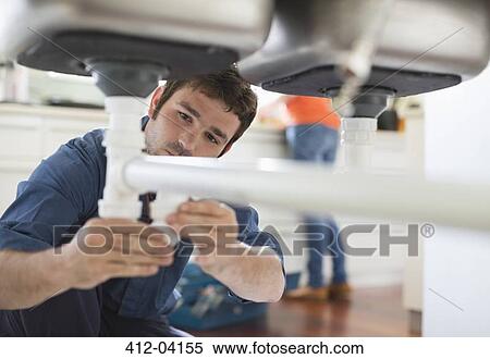 Plumber working on pipes under sink View Large Photo Image Stock Photography - Plumber working on pipes under sink. Fotosearch