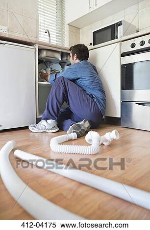 Plumber working on pipes under sink View Large Photo Image Stock Photography - Plumber working on pipes under sink. Fotosearch