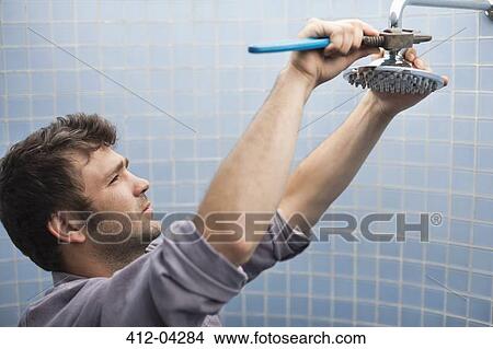 Plumber working on shower head in bathroom View Large Photo Image Picture - Plumber working on shower head in bathroom. Fotosearch