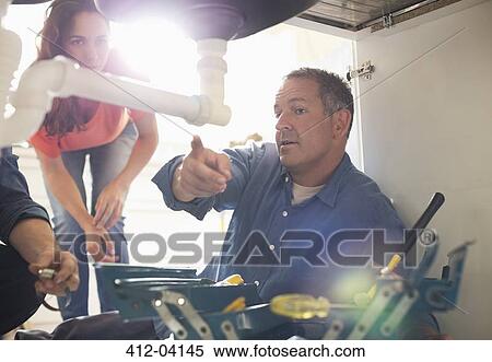 Plumbers working on pipes under sink View Large Photo Image Stock Photography - Plumbers working on pipes under sink. Fotosearch