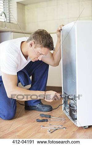 Repairman working on appliance in kitchen View Large Photo Image Stock Image - Repairman working on appliance in kitchen. Fotosearch