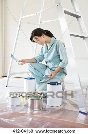 Woman examining paint cans View Large Photo Image Stock Photo - Woman examining paint cans. Fotosearch