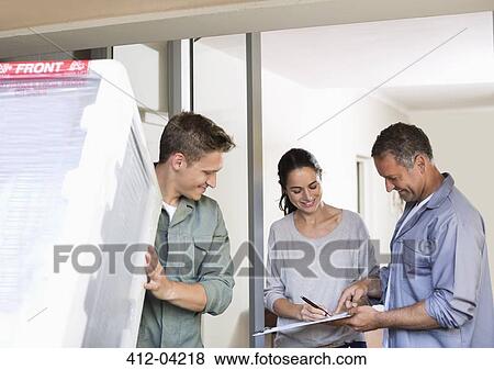 Woman signing for delivery at front door View Large Photo Image Stock Photo - Woman signing for delivery at front door. Fotosearch