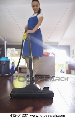 Woman vacuuming living room floor View Large Photo Image Stock Photo - Woman vacuuming living room floor. Fotosearch